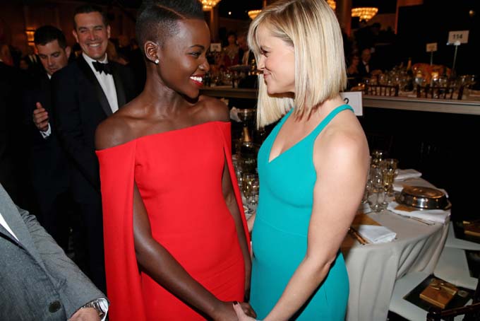 Lupita Nyong'o, left, and Reese Witherspoon speak in the audience at the 71st annual Golden Globe Awards at the Beverly Hilton Hotel on Sunday, Jan. 12, 2014, in Beverly Hills, Calif. (Photo by Matt Sayles/Invision/AP)