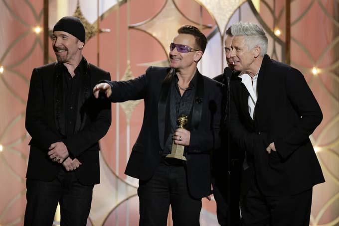 This image released by NBC shows, from left, The Edge, Bono, Larry Mullen, Jr., background and Adam Clayton of U2 with the award for best original song - in a motion picture for "Ordinary Love" from the film "Mandela: Long Walk to Freedom" during the 71st annual Golden Globe Awards at the Beverly Hilton Hotel on Sunday, Jan. 12, 2014, in Beverly Hills, Calif. (AP Photo/NBC, Paul Drinkwater)