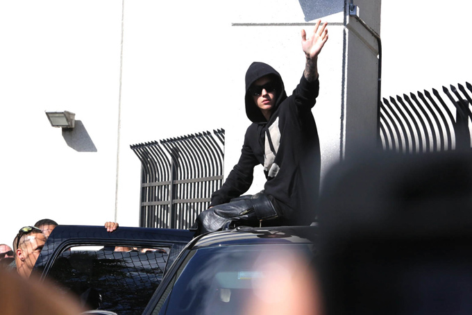 Singer Justin Bieber waves from atop an SUV as he leaves the Turner Guilford Knight Correctional Center, Thursday, Jan. 23, 2014, in Miami. (AP Photo/El Nuevo Herald, Hector Gabino) 