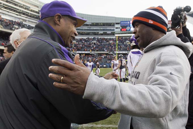 In this Nov. 25, 2012, file photo, Chicago Bears coach Lovie Smith, right, is greeted by Minnesota Vikings coach Leslie Frazier after the Bears' 28-10 win in an NFL football game in Chicago. A person familiar with the negotiations says former Vikings coach Frazier will be the Buccaneers' defensive coordinator. (AP Photo/Nam Y. Huh, File)
