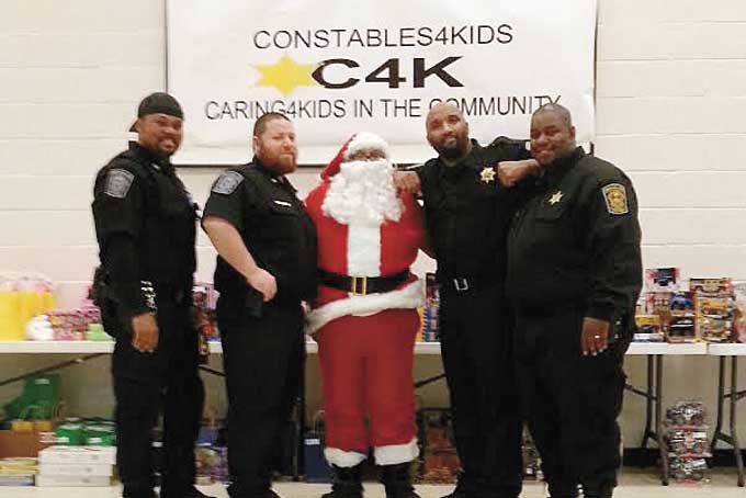 GIVING CONSTABLES—From left: constables Steve Wright, Michael Mosesso, Tony Adams as Santa, Lonzo Boyce and Lawrence Taylor. (Photo by Nikki Denton)