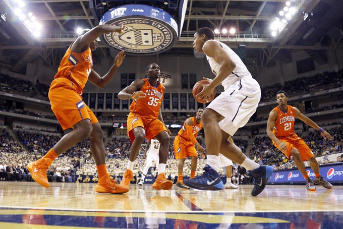 Pittsburgh's Michael Young, in white, drives to the hoop as Clemson's Josh Smith, left, and Landry Nnoko defend during the first half of an NCAA college basketball game on Tuesday, Jan. 21, 2014, in Pittsburgh. (AP Photo/Keith Srakocic)