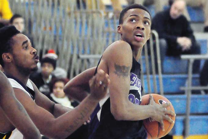 D.J. PORTER of USO goes thru the lane to the hoop against Carrick, Porter scored 18 points to lead the Eagles to a 82-55 win in the City League opener for both teams. (Photos by J. L. Martello)