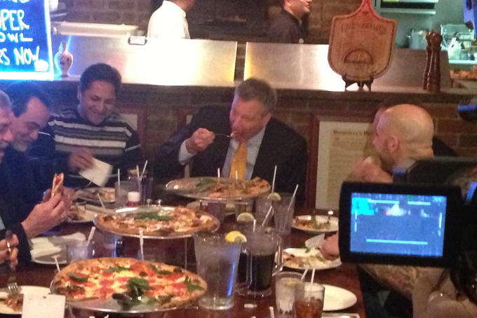 New York City Mayor Bill de Blasio, center, uses a knife and fork to pizza at Goodfellas Pizza in the Staten Island borough of New York, Friday, Jan. 10, 2014. (AP Photo/Jonathan Lemire)