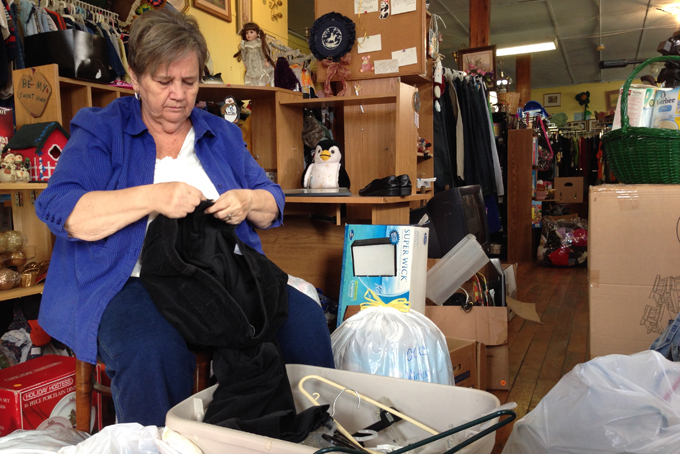 In this Nov. 21, 2013 photo, Cleda Turner, director of the Owsley County Outreach, folds clothes at the thrift store in Booneville, Ky. A drop in federal food assistance has struck Owsley County, in Kentucky’s Appalachian region, hard. (AP Photo/Dylan Lovan)