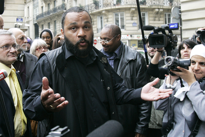 In this May 13, 2009 file photo, controversial French comic Dieudonne M'Bala M'Bala, known as Dieudonne, answers reporters as he heads for the interior Ministry to submit a list of candidates for the upcoming European elections, in Paris. (AP Photo/Remy de la Mauviniere, File) 