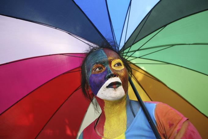 An activist with multicolored paint on her face and matching umbrella particiaptes a protest demanding equality for LGBTIQ (Lesbian, gay, bisexual, transgender and questioning) people in Medan, North Sumatra, Indonesia on Friday, May 31, 2012. In heavily Muslim Indonesia, gay sex is not criminalized, and many young, urban Indonesians are relatively tolerant of homosexuality, but most citizens consider it unacceptable. "Gay people are still living in fear," said King Oey, chairman of the country's main gay-rights group. (AP Photo/Binsar Bakkara)