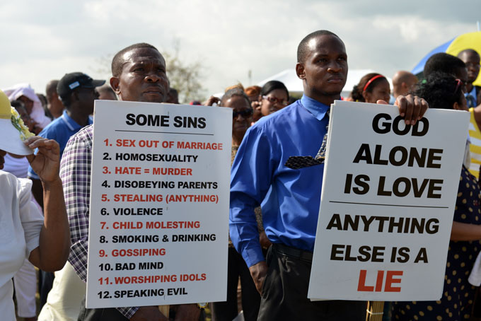 Jamaican churchgoers hold signs while attending an anti-gay rally in Kingston, Jamaica on Sunday, June 23, 2013. Several pastors in Jamaica led a revival meeting Sunday to oppose efforts to overturn the Caribbean country's anti-sodomy law and turn back what they see as increasing acceptance of homosexuality. (AP Photo/David McFadden)