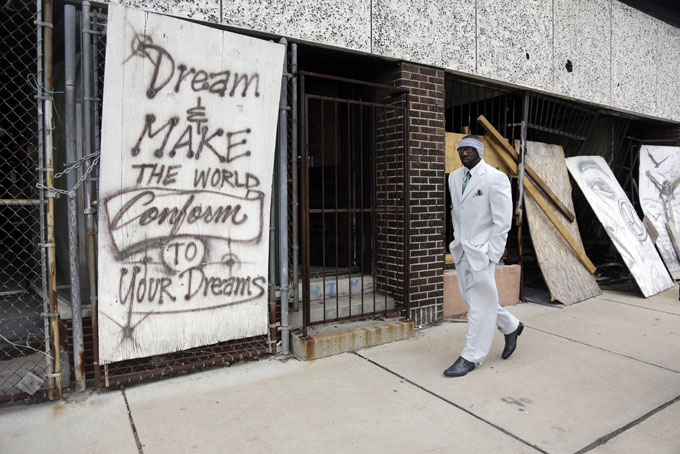 In this Thursday, Jan. 16, 2014 photo, Melvin White, founder of the Beloved Streets of America project, walks past a boarded up building during a tour of Dr. Martin Luther King Jr. Drive in St. Louis. (AP Photo/Jeff Roberson) (AP Photo/Jeff Roberson)