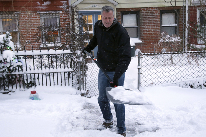 New York City Mayor Bill de Blasio shovels the sidewalk in front of his house in New York on Jan. 3. With less than 36 hours into his tenure, the first test of the new mayor’s leadership skills arrived in the form of a major winter storm. (AP Photo/Seth Wenig)