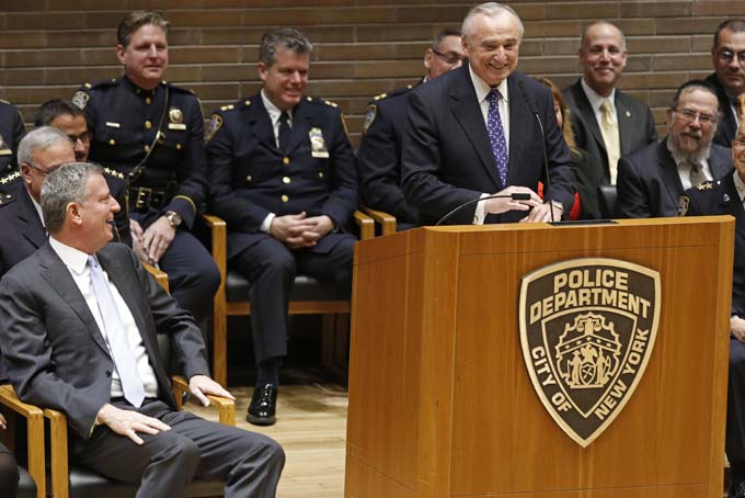 New York City Mayor Bill de Blasio, far left, laughs as the new New York City Police Commissioner William J. Bratton speaks following Brattons' swearing-in ceremony at police headquarters, Thursday, Jan. 2, 2014, in New York. (AP Photo/Kathy Willens)