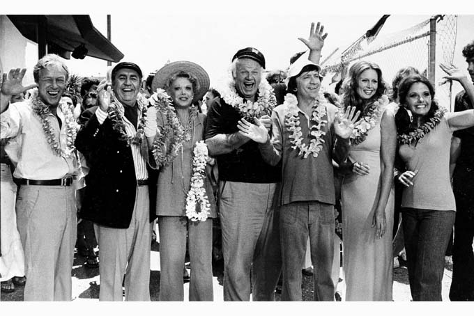 This Oct. 2, 1978 file photo shows the cast of "Gilligan's Island," from left, Russell Johnson, as the professor; Jim Backus as Thurston Howell III; Natalie Schafer, as Mrs. Howell III; Alan Hale Jr., as the skipper; Bob Denver, as Gilligan; Judith Baldwin replacing original cast member Tina Louise, as Ginger, and Dawn Wells, as Mary Ann, posing during filming of a two-hour reunion show, "The Return from Gilligan's Island," in Los Angeles. (AP Photo/Wally Fong, File)