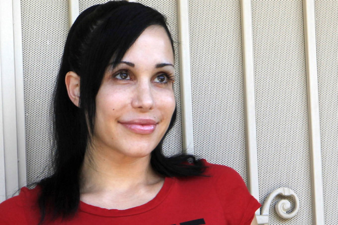 In this May 19, 2010 this file photo, Nadya Suleman stands outside her home in La Habra, Calif. (AP Photo/Damian Dovarganes, File)
