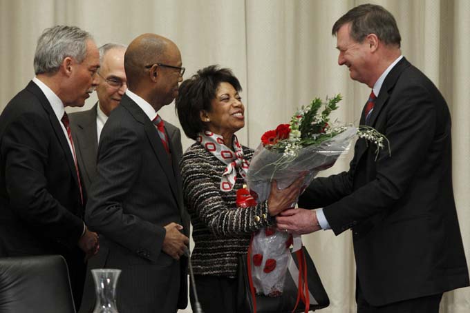 Ohio State University board trustee Jeffery Wadsworth, right, presents Brenda Drake, second from right, with flowers as her husband Dr. Michael Drake, third from right, looks on with board chair Robert Schottenstein, left, and interim university president Joseph Alutto after Dr. Drake was voted in as the incoming president of the university during a board meeting at the university Wednesday, Jan. 30, 2014. (AP Photo/Paul Vernon)