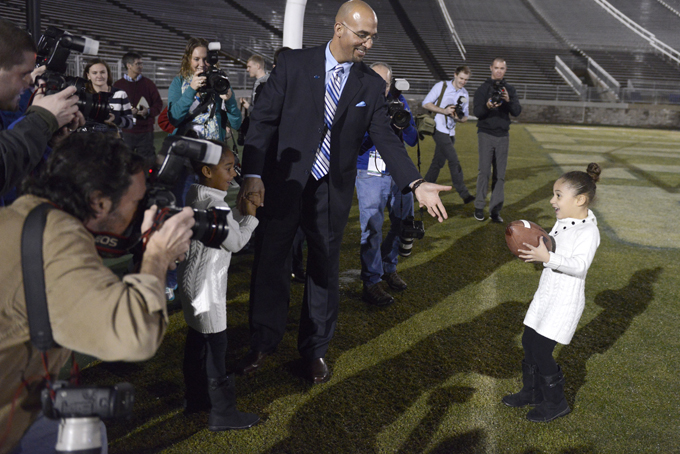 Penn State's new football coach James Franklin prepares to catch a football from his daughter, Addison, 5, after being introduced during an NCAA college football news conference at Beaver Stadium, Saturday, Jan. 11, 2014, in State College, Pa. Holding her father's hand is Shola, 6. (AP Photo/John Beale)