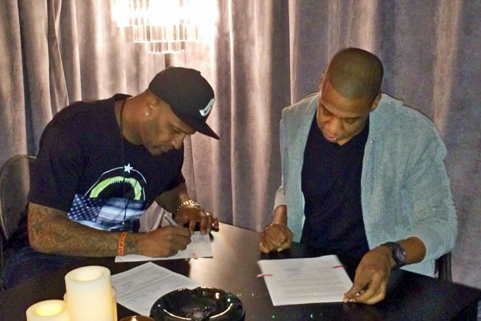 In this photo provided by Roc Nation Sports, New York Yankees pitcher CC Sabathia, left, signs papers with Jay-Z as Sabathia signs on with Jay-Z's sports agency, Roc Nation Sports, Thursday, Jan. 16, 2014, in New York. (AP Photo/Roc Nation Sports)