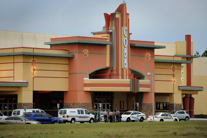 Authorities stand outside Cobb theater after a shooting in Wesley Chapel, Fla., Monday, Jan. 13, 2014. Authorities say a retired Tampa police officer has been charged with fatally shooting a man during an argument over cellphone use at the theater. (AP Photo/The Tampa Tribune, Cliff Mcbride)
