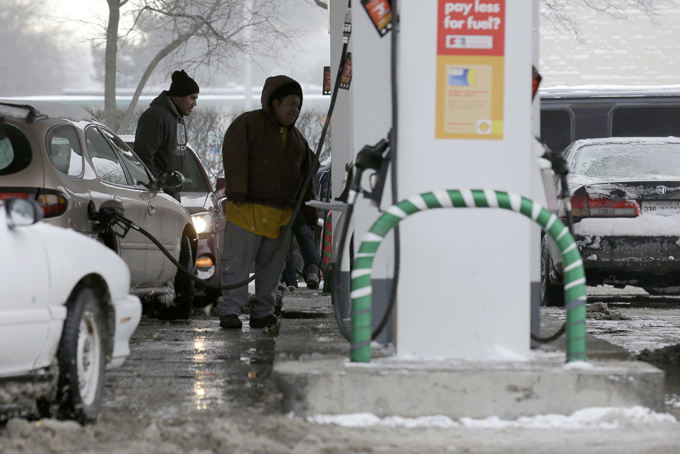 People fill their gas tank at a gas station in Chicago, Jan. 3,. (AP Photo/Nam Y. Huh)
