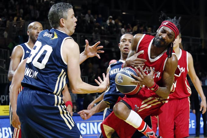 .S. Education Secretary Arne Duncan, left of the East team struggles with West's Snoop Dogg for a loose ball in the second half of the NBA All-Star Celebrity basketball game in New Orleans, Friday, Feb. 14, 2014. The East won 60-56. (AP Photo/Bill Haber)