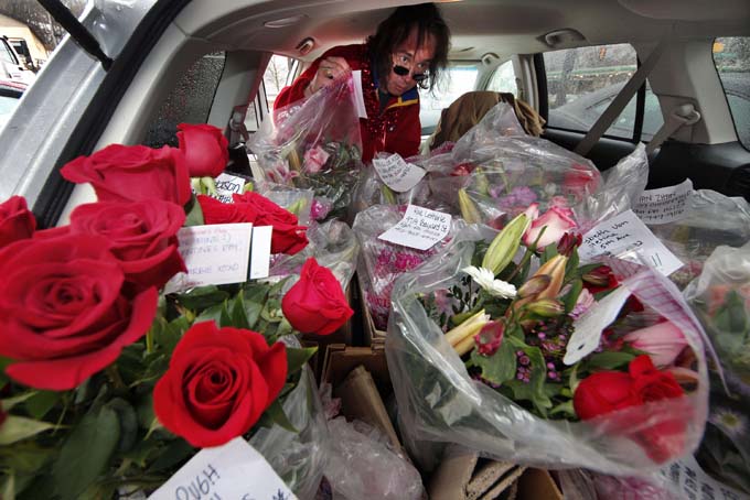 This Feb. 14, 2012 file photo shows a flower delivery driver loading his car with Valentine's Day deliveries in Pittsburgh. (AP Photo/Gene J. Puskar, File)