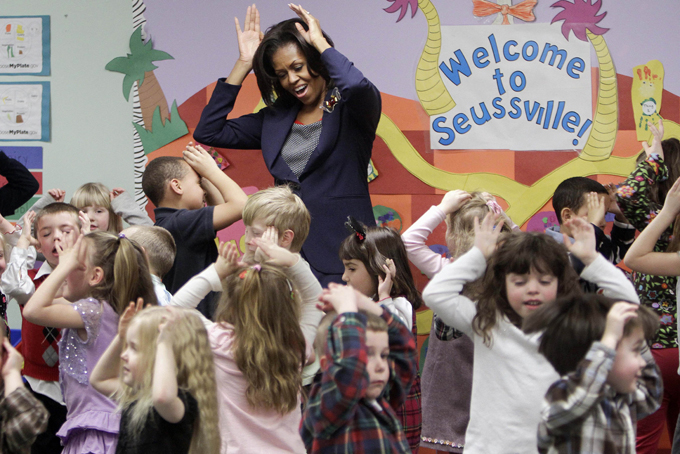 In this Friday, March 9, 2012 file photo, first lady Michelle Obama does a bunny hop dance with pre-schoolers at the Penacook Community Center in Concord, N.H., as part of her Let's Move initiative. (AP Photo/Jim Cole)