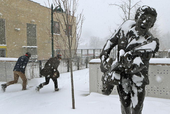  Two people duck into the blowing snow as they leave the U City Loop next to the statue of Chuck Berry on Sunday morning, Jan. 5, 201, in St. Louis. Heavy snow combined with strong winds and bitter cold created a dangerous winter mix Sunday over much of Missouri. (AP Photo/St. Louis Post-Dispatch, J.B. Forbes ) 