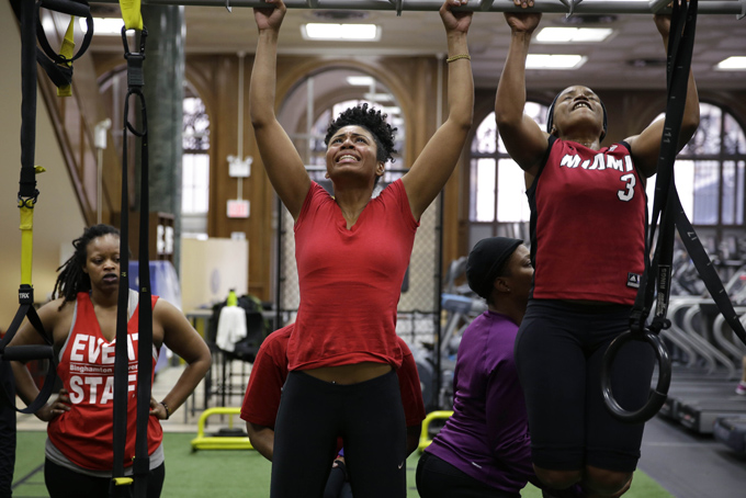 Hildany Santana, center, and Giselle King, right, do pull-ups during a training session in New York, Sunday, Jan. 19, 2014. Santana and King are training to become some of the few female firefighters in the New York City Fire Department. (AP Photo/Seth Wenig)