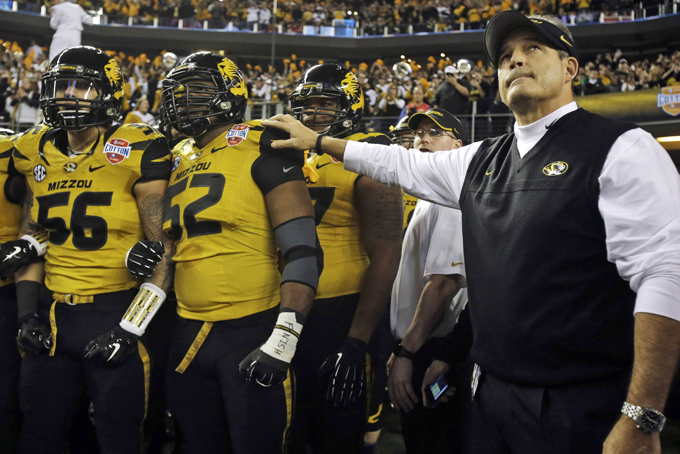 In this Jan. 3, 2014 file photo, Missouri head coach Gary Pinkel, right, and players, including offensive linesman Robert Luce (56) and defensive lineman Michael Sam (52), prepare to take the field for the Cotton Bowl NCAA college football game against Oklahoma State, in Arlington, Texas. Sam, Missouri's All-America defensive end came out to the entire country Sunday night, Feb. 9, 2014, and could become the first openly gay player in America's most popular sport. (AP Photo/Tim Sharp, File)