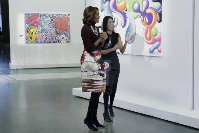 First lady Michelle Obama is escorted by Rose Cameron, CEO and founder of WAT-AAH!, a line of bottled water targeted to kids and teens, as they view the "Taking Back the Streets" art exhibit at the New Museum, in New York, Thursday, Feb. 20, 2014. (AP Photo/Richard Drew)