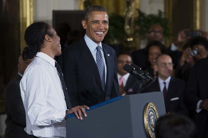 President Barack Obama laughs as he is introduced by Christian Champagne, 18, a senior at Hyde Park Career Academy in Chicago, during an event in the East Room of the White House in Washington, Thursday, Feb. 27, 2014, to promote his "My Brother's Keeper" initiative. (AP Photo/ Evan Vucci)