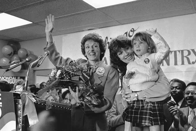 In this Sept. 10, 1984 file photo, Joan Mondale, wife of the Democratic presidential candidate Walter Mondale, center, waves to the campaign workers gathered at the Illinois headquarters for the Mondale-Ferraro election effort, in Chicago. Mondale is flanked by campaign worker Julie Grace, holdings Lauren Jascula, who also wanted to show her support.  (AP Photo/Charlie Knoblock, File)