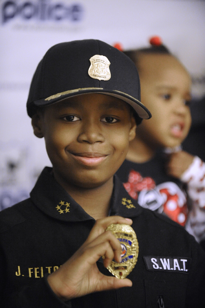 In a Jan. 31, 2014 file photo, Jayvon Felton, 9, flashes his badge after he was named Chief of Police for a day by Detroit Police Chief James Craig at Detroit Public Safety Headquarters in Detroit. (AP Photo/Detroit News, David Coates) 