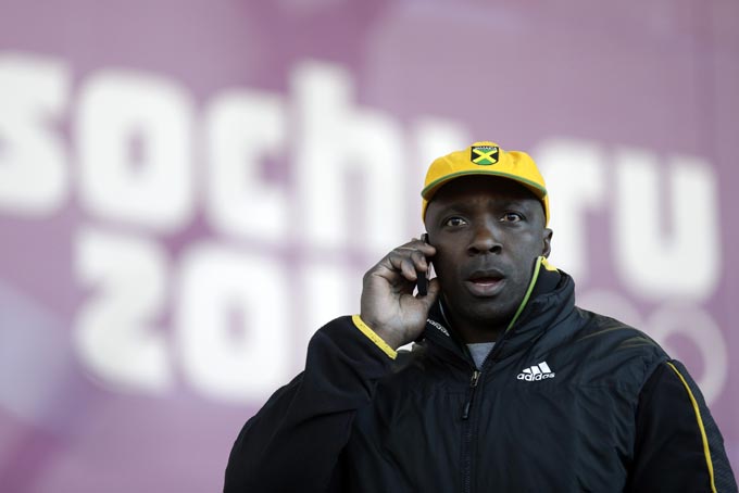 Winston Watts, the driver for JAM-1 of Jamaica, speaks on the phone after arriving at the sliding center during a training session for the men's two-man bobsled at the 2014 Winter Olympics, Wednesday, Feb. 5, 2014, in Krasnaya Polyana, Russia. (AP Photo/Natacha Pisarenko)