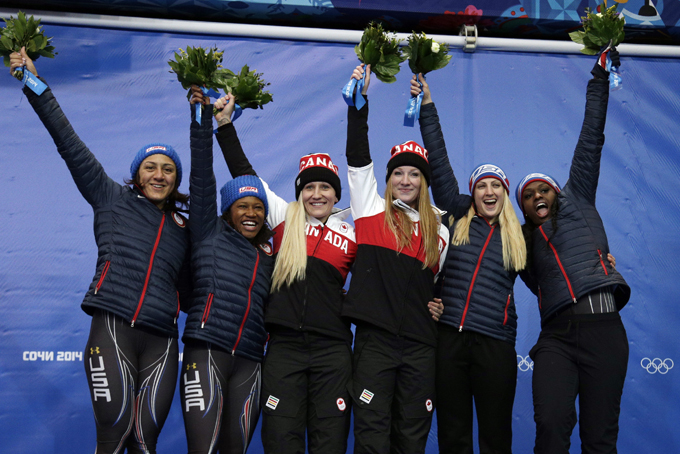 From left to right, silver medal winners from the United States Elana Meyers and Lauryn Williams, gold medal winners from Canada Kaillie Humphries and Heather Moyse, and bronze medal winners from the United States Jamie Greubel and Aja Evans pose during the flower ceremony during the women's bobsled competition at the 2014 Winter Olympics, Wednesday, Feb. 19, 2014, in Krasnaya Polyana, Russia. (AP Photo/Michael Sohn)