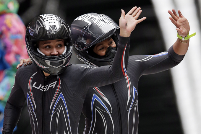 The team from the United States USA-3, piloted by Jazmine Fenlator with brakeman Lolo Jones, left, wave to fans after their final run during the women's bobsled competition at the 2014 Winter Olympics, Feb. 19, in Krasnaya Polyana, Russia. (AP Photo/Michael Sohn)