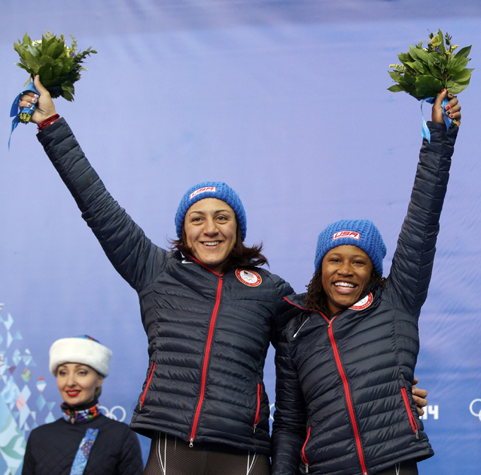 Silver medal winners from the United States Elana Meyers and Lauryn Williams, pose during the flower ceremony during the women's bobsled competition at the 2014 Winter Olympics, Wednesday, Feb. 19, 2014, in Krasnaya Polyana, Russia. (AP Photo/Michael Sohn)