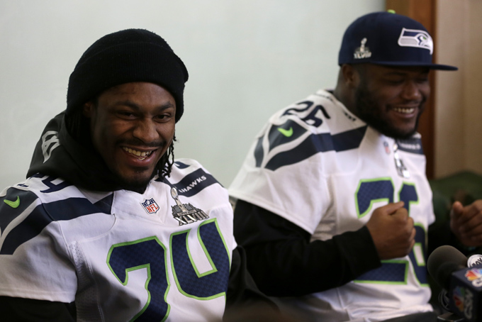Seattle Seahawks running back Marshawn Lynch, left, laughs along side teammate Michael Robinson as the participate in a media availability Thursday, Jan. 30, 2014, in Jersey City, N.J. (AP Photo)