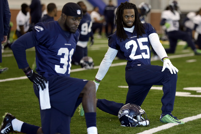 Seattle Seahawks safety Kam Chancellor, left, and cornerback Richard Sherman warm up with their teammates at the start of NFL football practice Wednesday, Jan. 29, 2014, in East Rutherford, N.J. The Seahawks and the Denver Broncos are scheduled to play in the Super Bowl XLVIII football game Sunday, Feb. 2, 2014. (AP Photo/Jeff Roberson)