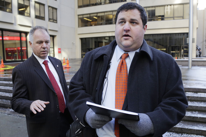 Mason Tvert, right, spokesman for the Marijuana Policy Project, prepares to deliver a petition to National Football League headquarters, Wednesday, Jan. 29, 2014, in New York. Kevin Fitzgerald, left, director of building security, waits for the handoff. T(AP Photo/Mark Lennihan)