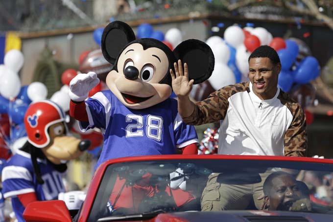 The 2014 Super Bowl MVP Malcolm Smith, of the Seattle Seahawks, catches a football thrown to him as he rides in a parade at Walt Disney World with Mickey Mouse, Monday, Feb. 3, 2014, in Lake Buena Vista, Fla. The Seahawks defeated the Denver Broncos 43-8 in Sunday's Super Bowl XLVIII NFL football game in East Rutherford, N.J. (AP Photo/John Raoux)