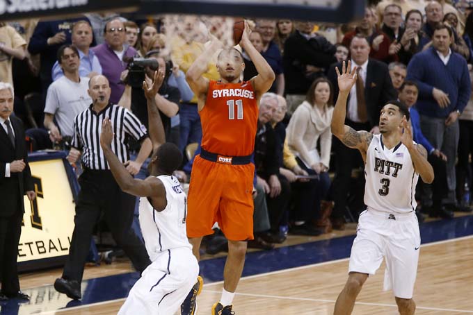 Syracuse's Tyler Ennis (11) shoots 3-pointer between Pittsburgh's Cameron Wright (3) and Josh Newkirk, left, in the final second of an NCAA college basketball game Wednesday, Feb. 12, 2014, in Pittsburgh. (AP Photo/Keith Srakocic)