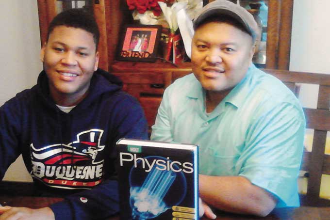 UNCERTAINTY PRINCIPLE—Thaddeus Morris with his father, Gregory Morris, and the single textbook he has been issued in his nearly two years at Pittsburgh’s Perry High School.