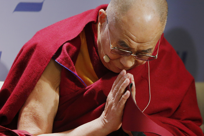 Tibetan spiritual leader the Dalai Lama acknowledges the audience before speaking at an event entitled: "Happiness, Free Enterprise, and Human Flourishing" Thursday, Feb. 20, 2014, at the American Enterprise Institute in Washington. (AP Photo/Charles Dharapak)