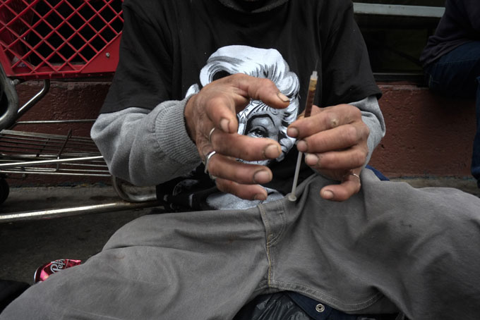 In this Monday, May 6, 2013 file photo, a drug addict prepares a needle to inject himself with heroin in front of a church in the Skid Row area of Los Angeles. It's not a rare scene on Skid Row to spot addicts using drugs in the open, even when police patrol the area. Jim Hall, an epidemiologist who studies substance abuse at Nova Southeastern University in Fort Lauderdale, Fla. says, the striking thing about heroin’s most recent incarnation in the early 21st Century, is that a drug that was once largely confined to major cities is spreading into suburban and rural towns across America, where it is used predominantly by young adults between the ages of 18 and 29. "We haven’t really seen something this rapid since probably the spread of cocaine and crack in the mid-1980s," Hall said. (AP Photo/Jae C. Hong)