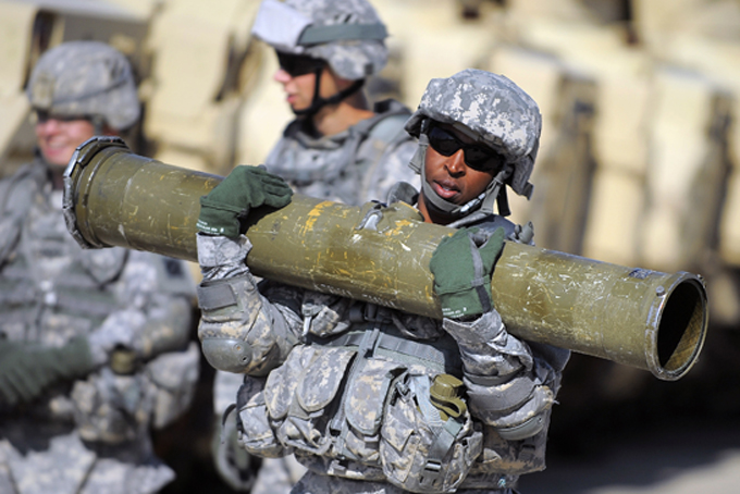 U.S. Army Corp. Jacqueline Beachum carries a 65-pound T.O.W. missile several yards before loading the dummy missile to the launcher of a Bradley Fighting Vehicle during a physical demands study, Tuesday, Feb. 25, 2014, in Ft. Stewart, Ga.  (AP Photo/Stephen B. Morton)
