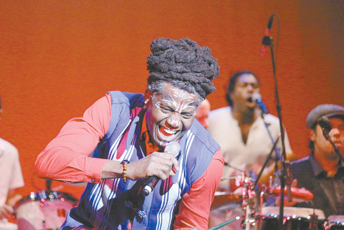 AMAYO singing on stage with the group Antibalas. 