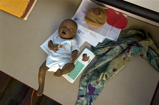 A doll used for breast-feeding training sits on a table with literature during a monthly gathering that promotes breast-feeding at a YMCA in Milwaukee. Breast-feeding is thought to help protect against higher rates of infant mortality and childhood obesity, to more breast cancer deaths and heart disease in adults - and it's much less common among U.S. black women than in whites and others. Rates have improved in recent years but the disparity remains. (AP Photo/Darren Hauck)