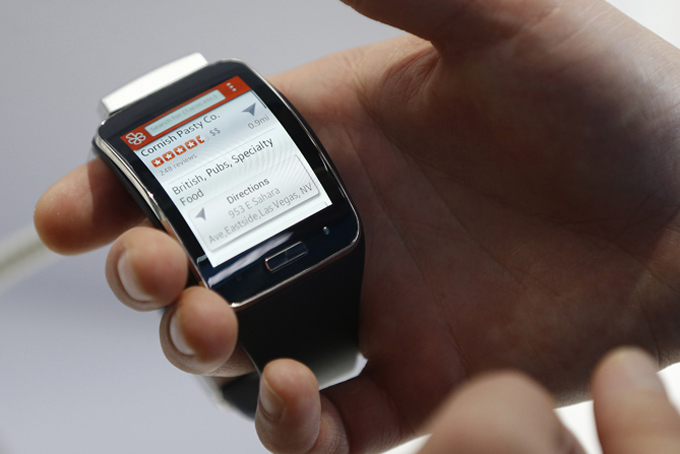 In this Jan. 6, 2015 file photo, an employee demonstrates the Samsung Gear S smartwatch at the Samsung booth during the International CES in Las Vegas. (AP Photo/John Locher, File)