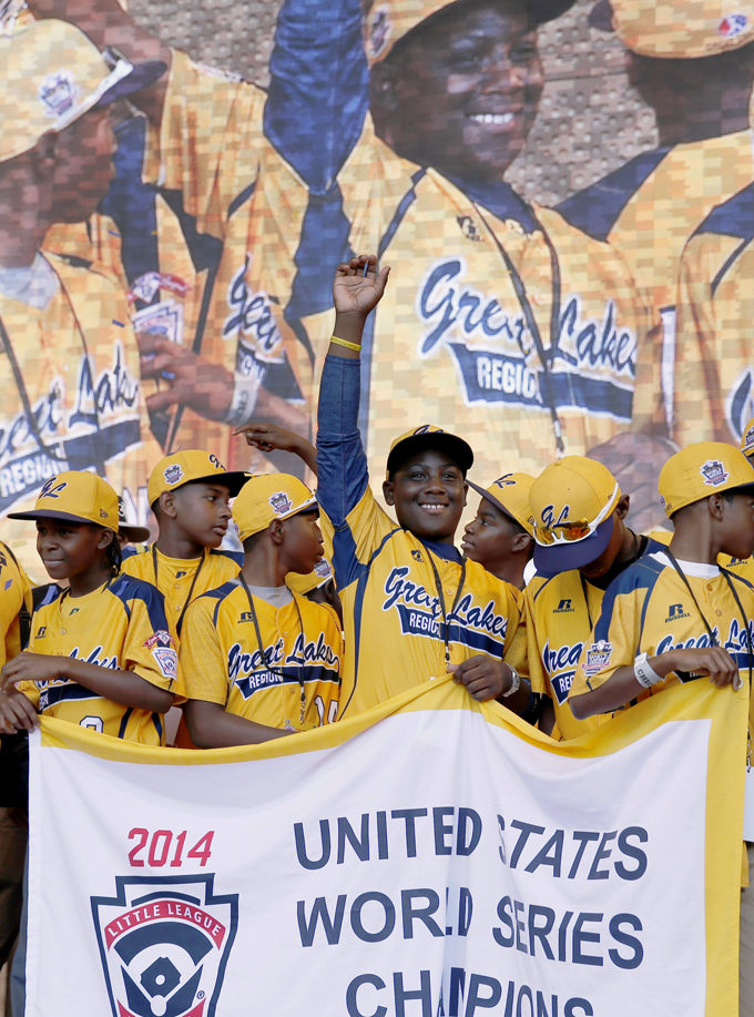 FILE - In this Aug. 27, 2014 file photo, members of the Jackie Robinson West All Stars Little League baseball team participate in a rally in Chicago celebrating the team's U.S. Little League Championship. Little League International has stripped Chicago's Jackie Robinson West team of its national title after finding the team falsified its boundary map. The league made the announcement Wednesday morning, Feb. 11, 2015, saying the Chicago team violated regulations by placing players on the team who didn’t qualify because they lived outside the team’s boundaries. Little League International also suspended Jackie Robinson West manager Darold Butler from league activity. (AP Photo/Charles Rex Arbogast, File)