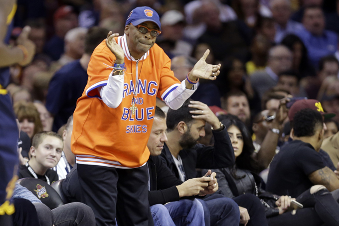In this Oct. 30, 2014 file photo, filmmaker Spike Lee cheers during an NBA basketball game between the New York Knicks and Cleveland Cavaliers in Cleveland. Lee is slated to coach the Sprint NBA All-Star Celebrity Game, which will kick off festivities for the All-Star weekend on Feb. 13-15, 2015. (AP Photo/Tony Dejak)